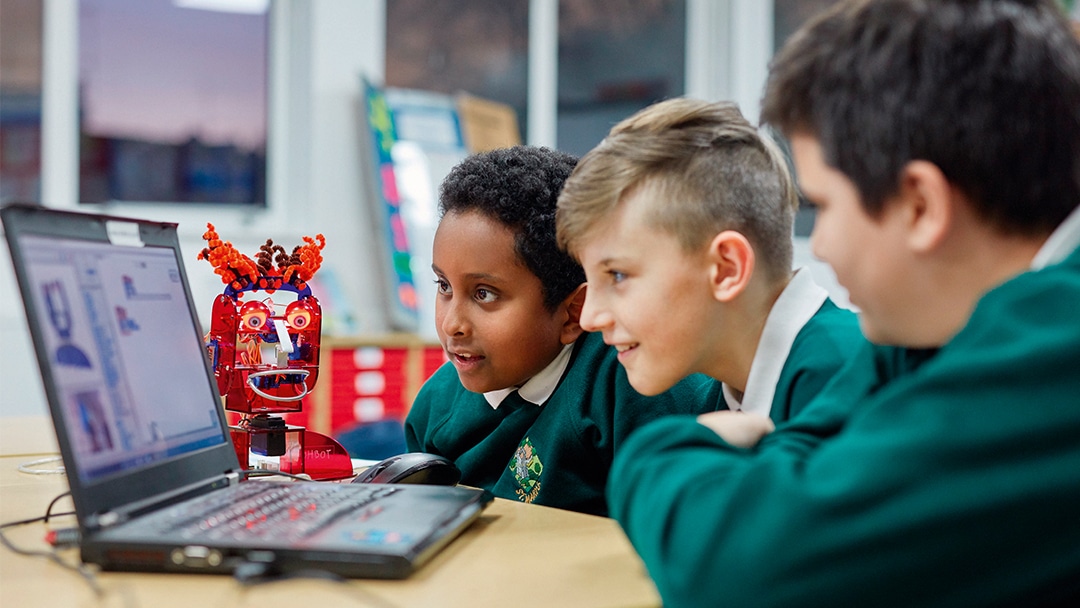 Young boys using a coding robot in the classroom