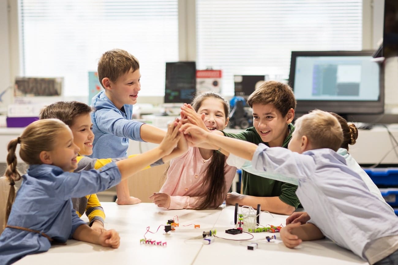 school children high five each other in a circle