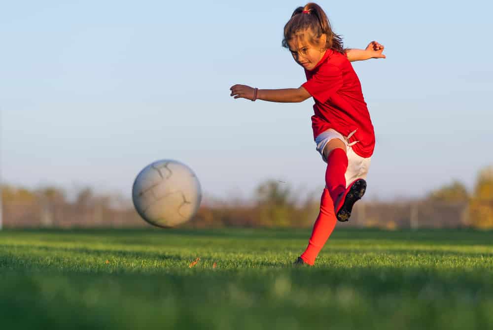 girl kicking football