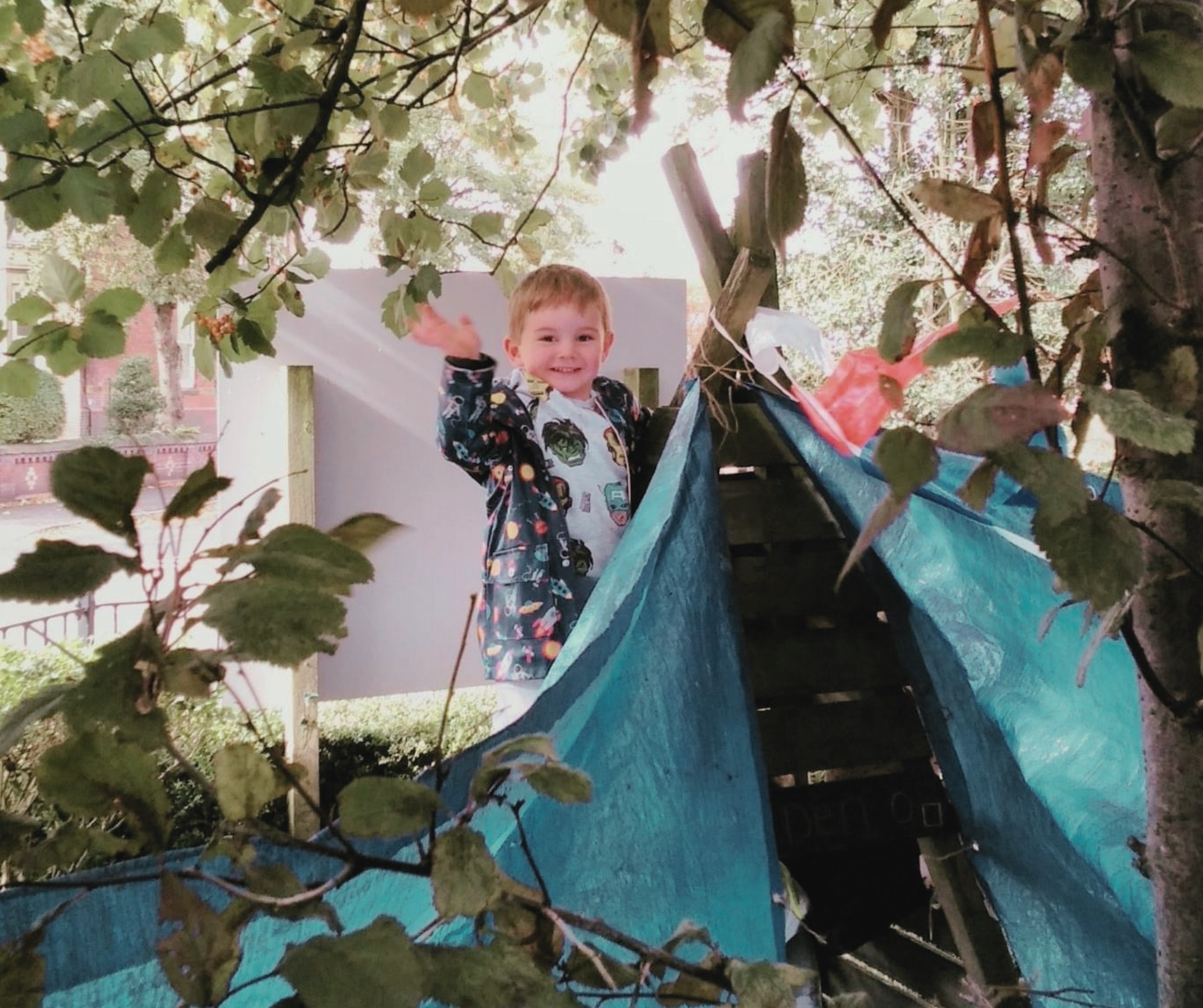 boy creating yurt, nature-based play