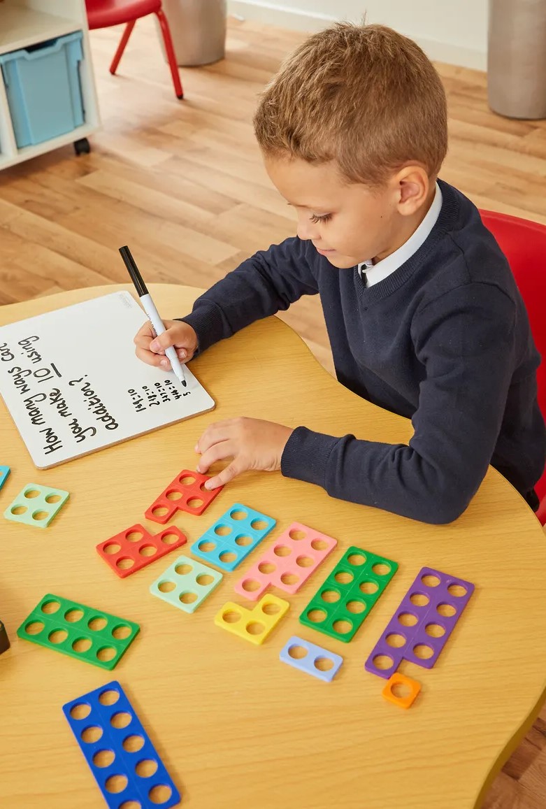 Boy using Numicon shapes- Numicon activities