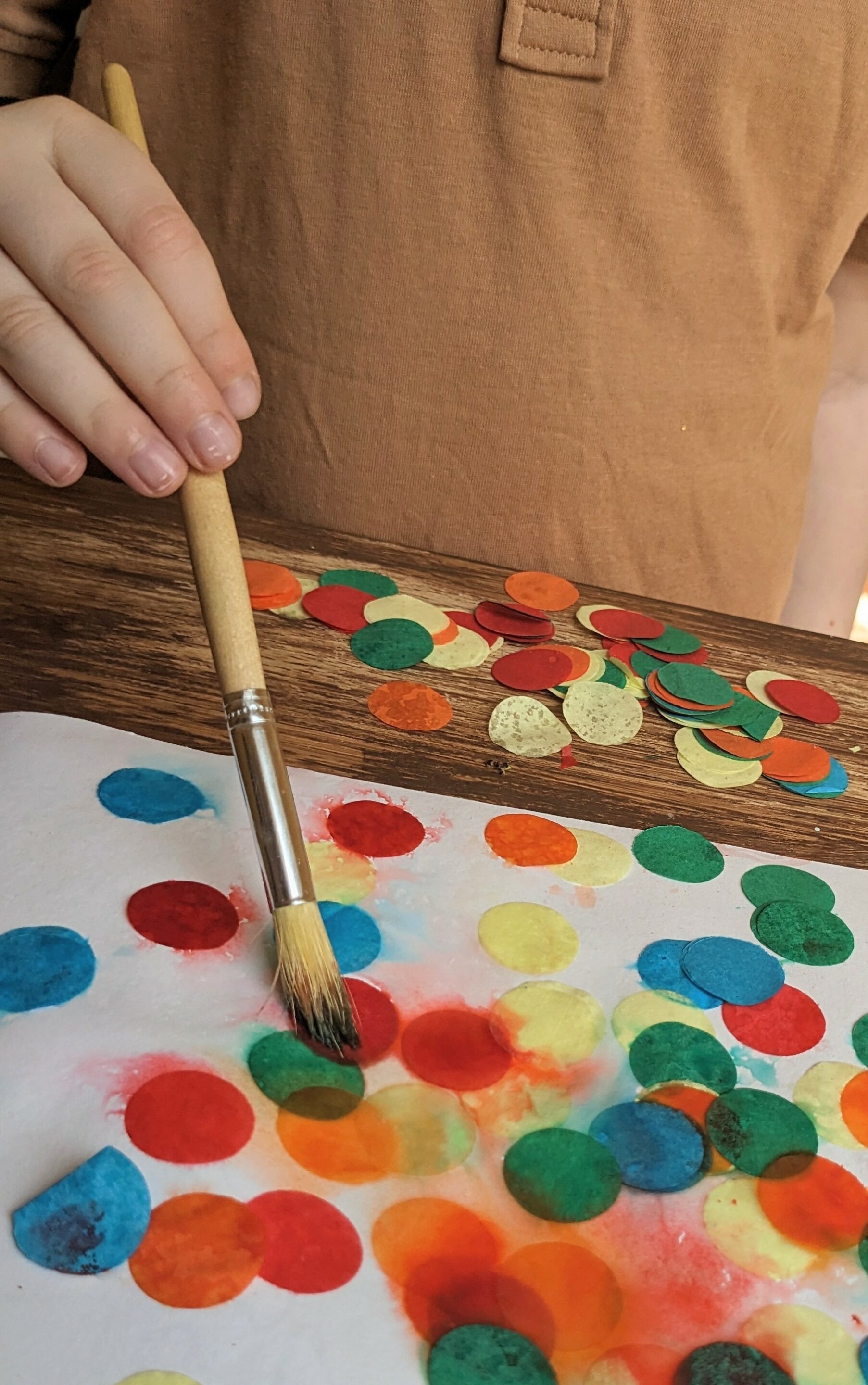 paint brush covering confetti with water