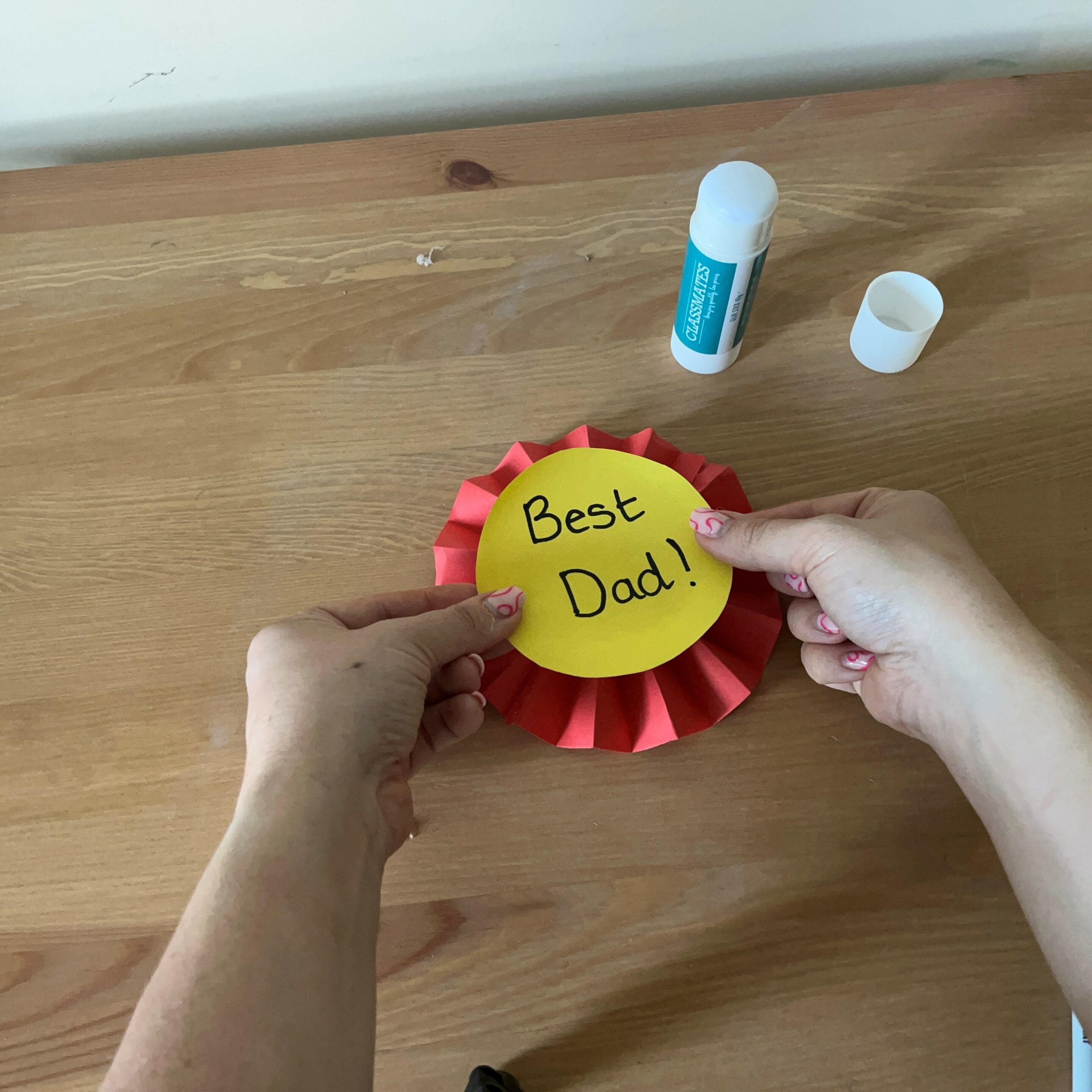 sticking father's day message onto rosette