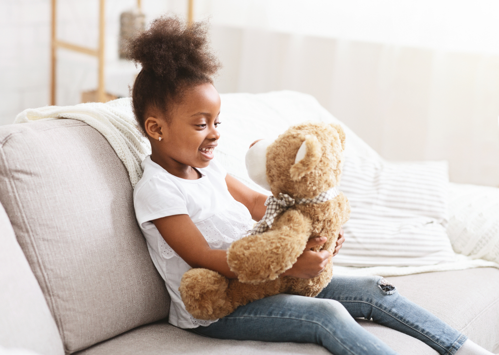 Child smiling at teddy bear